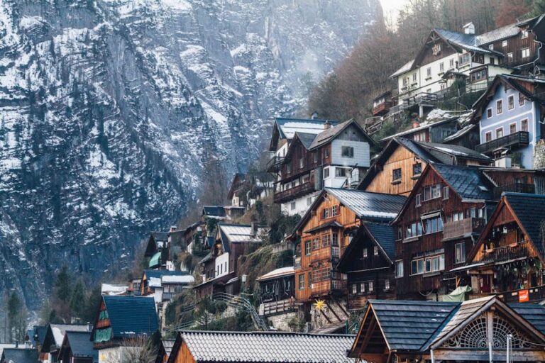 Charming wooden homes nestled on a snowy cliffside in Liezen, Austria, during winter.