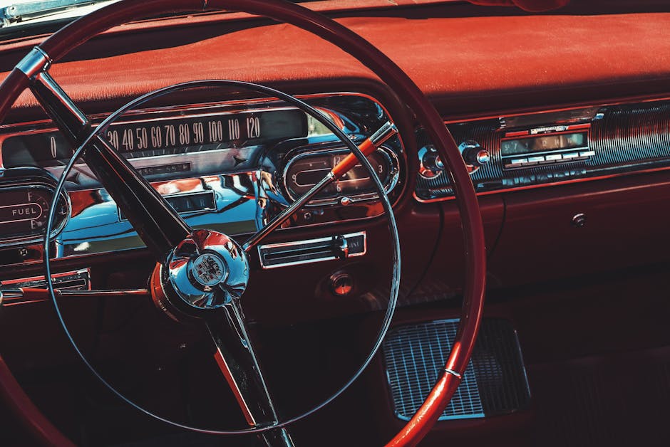 Close-up of a vintage convertible car's steering wheel and dashboard, showcasing classic design.
