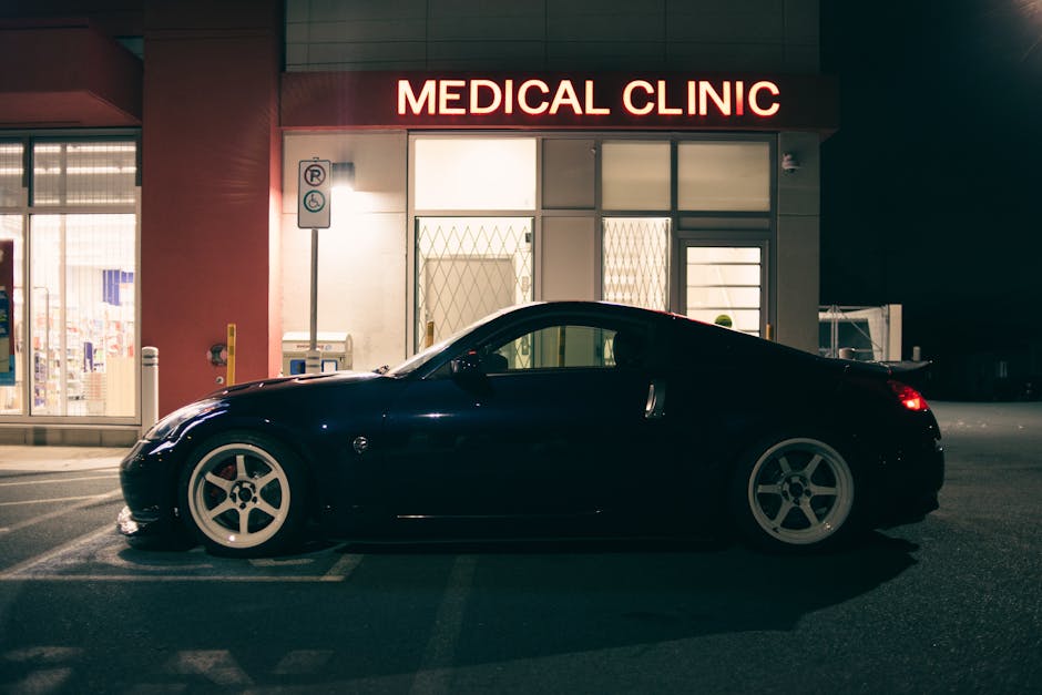 Stylish Nissan 350Z sports car parked at night in front of a medical clinic with illuminated signage.