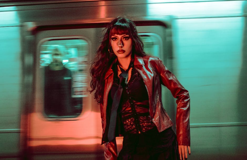 Fashionable woman posing in a colorful subway station with moving train background.