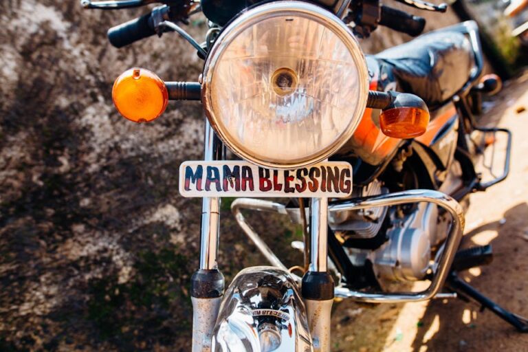 Front view of a classic motorcycle with 'Mama Blessing' plate outdoors.