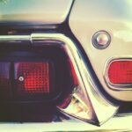 Detailed close-up of a classic car tail light with a vintage aesthetic tone.