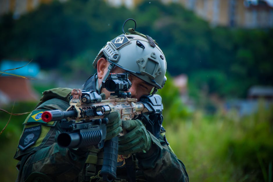 Close-up of a soldier in tactical gear aiming a rifle outdoors. Military precision and focus.