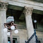 An elegant view of classic architectural columns with an antique street lamp, ideal for urban landscapes.