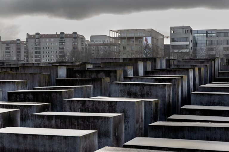 Dramatic view of the Holocaust Memorial in Berlin against a cloudy sky.