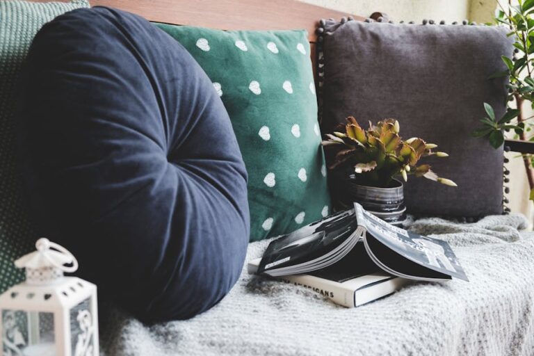 Inviting seating area with round and square cushions, book, and plant in natural light.