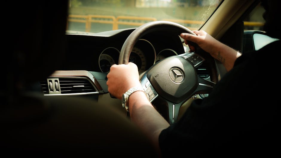 Close-up of a driver steering a Mercedes-Benz through Bengaluru, India.