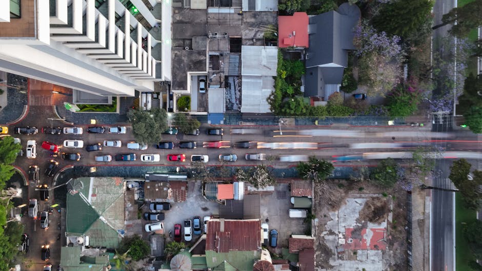 Top-down drone shot capturing vehicles and buildings in a bustling urban cityscape.