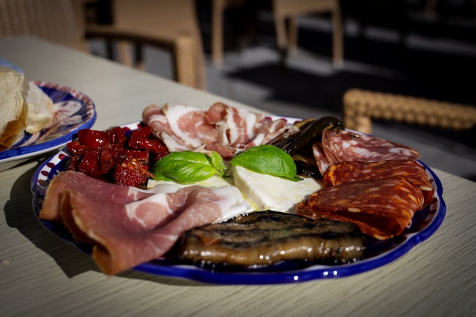 An appetizing Italian antipasto platter featuring cured meats, cheese, and roasted vegetables.