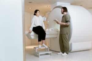 A patient consults with a technician in a modern MRI room, highlighting advanced healthcare facilities.